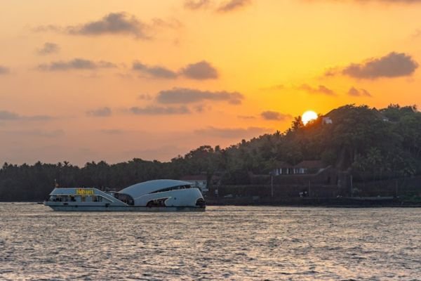 Nirvana cruise silhouetted against a golden Goa sunset with orange sky